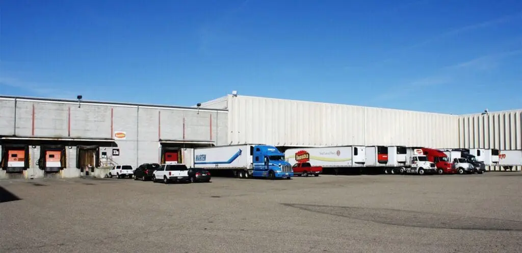 A group of trucks parked in front of a warehouse.