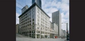 An image of a building with tall buildings in the background.