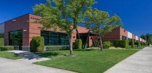 A brick building with grass and trees in front of it.