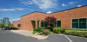 A brick building with a parking lot in front of it.