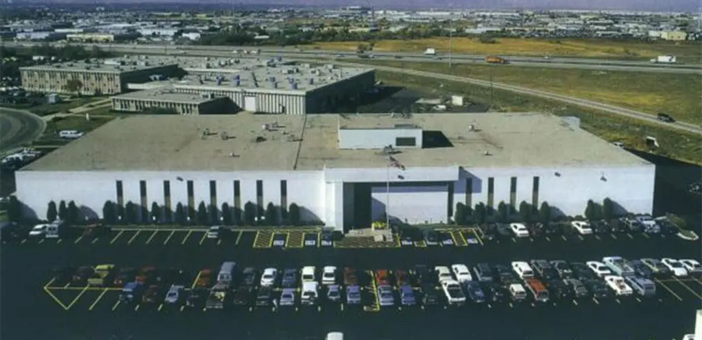 An aerial view of a large building with cars parked in front of it.