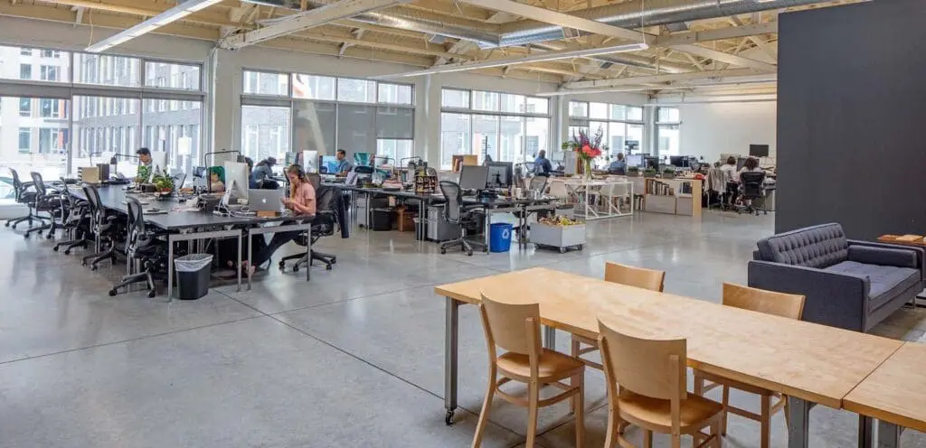 A large open office with many desks and tables.