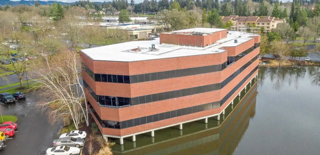 An aerial view of an office building near a lake.