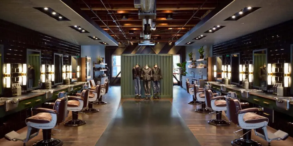 A barber shop with a long line of chairs.