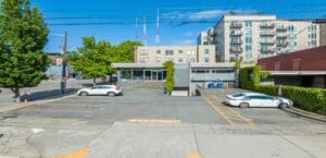 A parking lot with cars parked in front of a building.